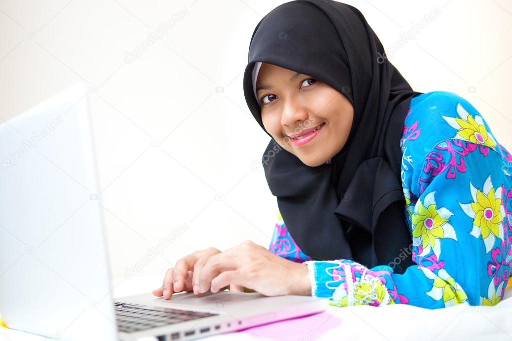 Beautiful young Muslim woman student using laptop