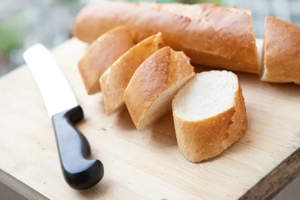 Baguete francesa recém-assada em tábua de madeira — Fotografia de Stock