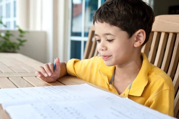 Mooie jonge jongen zijn huiswerk thuis — Stockfoto