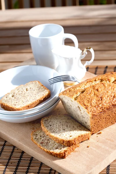 Banana bread on serving board at tea time — Stock Photo, Image