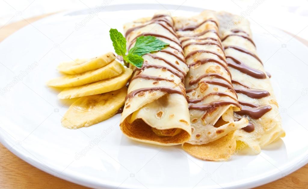 Delicious crepe with banana filling with chocolate sauce