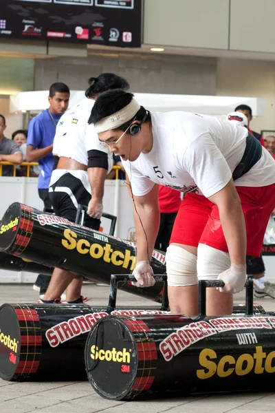 TOA PAYOH, SINGAPORE - MARCH 24 : Contender for Strongman Benjamin Soh attempts the 2 times 120 log walk in the Strongman Challenge 2012 on March 24, in Toa Payoh Hub, Singapore. — Stock Photo, Image