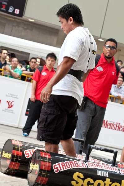 TOA PAYOH, SINGAPORE - MARCH 24 : Contender for Strongman Mohd Asri Abd Kadir attempts the 2 times 120 log walk in the Strongman Challenge 2012 on March 24, in Toa Payoh Hub, Singapore. — Stock Photo, Image