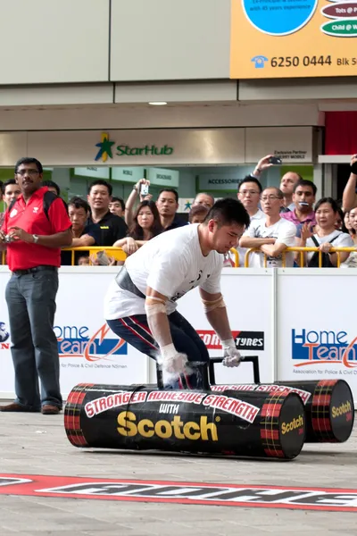 TOA PAYOH, SINGAPORE - MARCH 24 : Contender for Strongman Tan Bin Soon attempts the 2 times 120 log walk in the Strongman Challenge 2012 on March 24, in Toa Payoh Hub, Singapore. — Stock Photo, Image