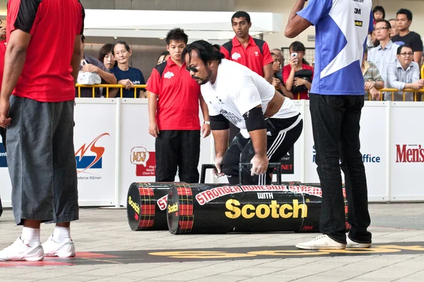 TOA PAYOH, SINGAPORE - MARCH 24 : Contender for Strongman Yusri Bin Ali attempts the 2 times 120 log walk in the Strongman Challenge 2012 on March 24, in Toa Payoh Hub, Singapore. — Stock Photo, Image