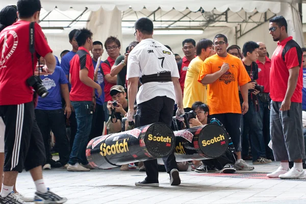 TOA PAYOH, SINGAPORE - MARCH 24 : Contender for Strongman Lloyd Lee approaching finishing line the 2 times 120 log walk in the Strongman Challenge 2012 on March 24, in Toa Payoh Hub, Singapore. — Stock Photo, Image