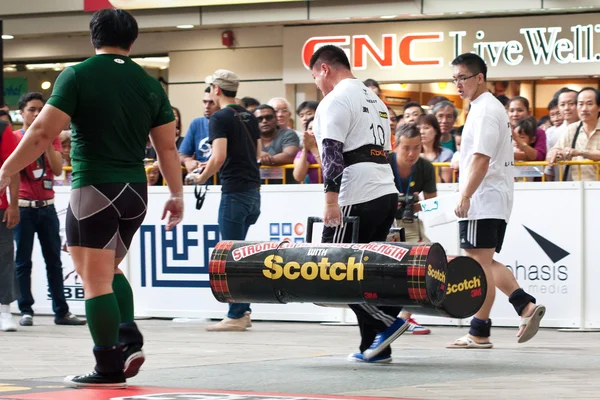 TOA PAYOH, SINGAPORE - MARCH 24 : Contender for Strongman Raphael Teo attempts the 2 times 120 log walk in the Strongman Challenge 2012 on March 24, in Toa Payoh Hub, Singapore. — Stock Photo, Image