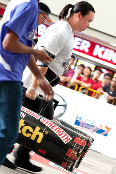 TOA PAYOH, SINGAPUR - 24 DE MARZO: Contender para el Fuerte Keith Wong intenta el 2 veces 120 paseo de troncos en el Desafío Strongman 2012 el 24 de marzo, en Toa Payoh Hub, Singapur . — Foto de Stock