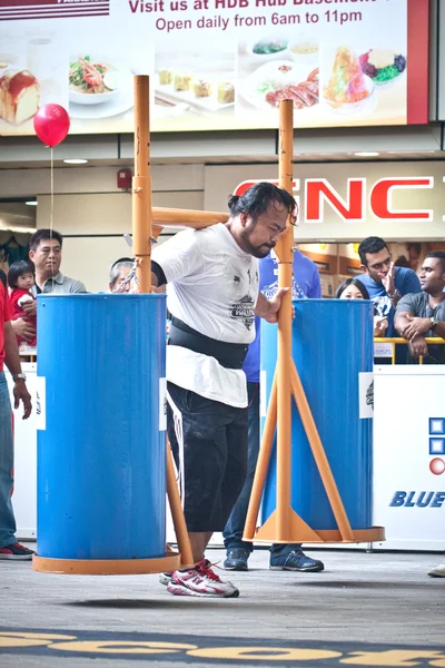 TOA PAYOH, SINGAPORE - MARCH 24 : Contender for Strongman Yusri Bin Ali attempts the 300kg Yoke walk in the Strongman Challenge 2012 on March 24, in Toa Payoh Hub, Singapore. — Stock Photo, Image