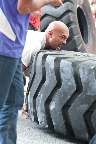 TOA PAYOH, SINGAPORE - MARCH 24 : Contender for Strongman Sulaiman Ismail attempting the six times 350kg tyre flip category in the Strongman Challenge 2012 on March 24, in Toa Payoh Hub, Singapore. — Stock Photo, Image