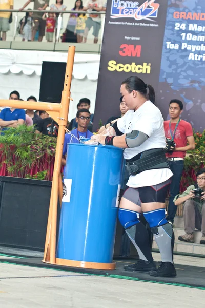 TOA PAYOH, SINGAPORE - 24 MARZO: Contender per Strongman Keith Wong nella sua passeggiata di 300kg giogo nella Strongman Challenge 2012 il 24 marzo, a Toa Payoh Hub, Singapore . Foto Stock Royalty Free