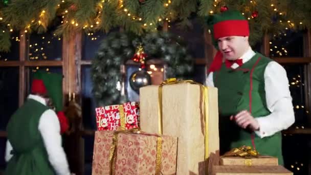 실내에 상자가 재미있는 요정들 크리스마스 아이들을 선물을 올리는 즐거운 캐릭터들 — 비디오