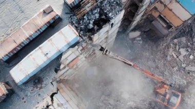 Bir kazıcıyla beton yapıların sökülmesi. Konut binalarının gelecekteki gelişimi için çok katlı bir binanın yıkımı
