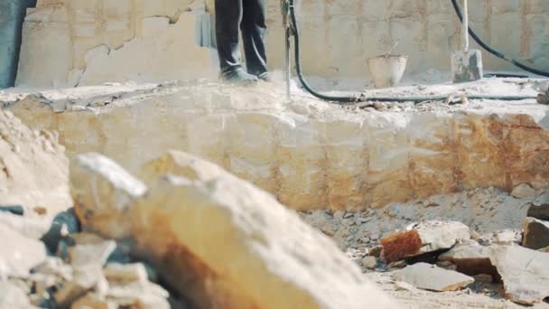 석장에서 일하는 사람들은 화강암 망치로 구멍을 뚫습니다 회전식 드릴을 이용하여 — 비디오