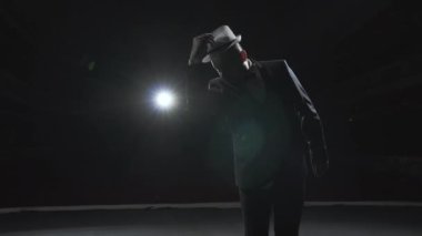 Smokinli bir dansçı şapkasını takar ve sahnede dans eder. Michael Jackson 'a benzeyen bir dansçının silueti..