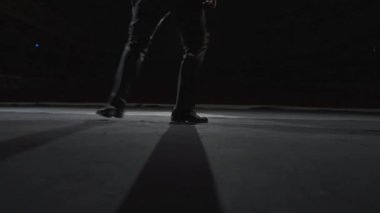 Michael Jackson ay yürüyüşü dansı. Sahne ışıkları altında, karanlık bir tiyatro sahnesinde ayakkabılı bir dansçının bacakları. Yakın plan..