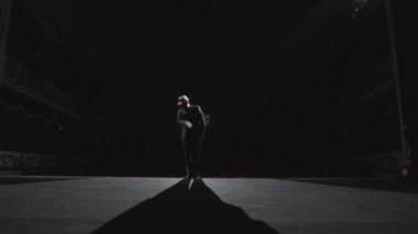 Michael Jackson 'a benzeyen bir dansçının silueti. Patlama tarzında dans eden atletik bir adam. Karanlık bir tiyatro sahnesinde sahne ışıkları altında bir adam..