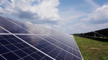 Modern fotovoltaik güneş pillerinin yakın çekimi. Sürdürülebilir enerji güneş panellerinin sıraları gökyüzünün arka planında bulutlarla çevrili..