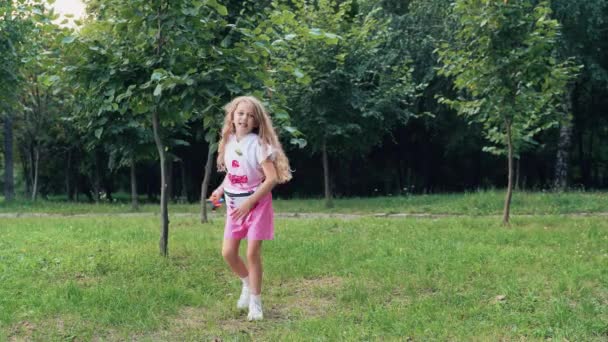 Mała Radosna Dziewczynka Zabawkowym Wiatrakiem Rękach Parku Trawie Skacze Tańczy — Wideo stockowe