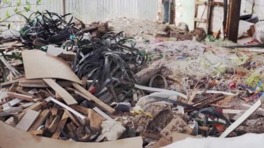 Bahçede üretim atığı var. Çöp yığını, yonga parçaları, plastik bantlar. Çevre kirliliği.