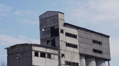 Kırık camları olan eski terk edilmiş bir fabrikanın yıkılmış beton ve tuğla binaları. Ukrayna 'daki sanayi binaları.