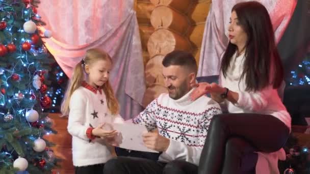 Счастливая Семья Сидит Кресле Рядом Елкой Деревянном Доме Девушка Картинкой — стоковое видео