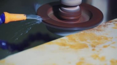 Makinenin üstündeki öğütücü taş. Fabrikada bir taş levhanın köşesinde su kullanarak..