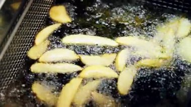 Kaynar yağda patates pişirmek. Fast food restoranında patates kızartması kızartılır..