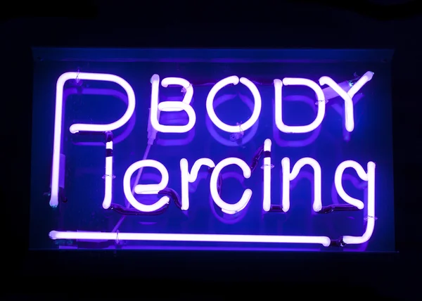 Těla piercing neonový nápis — Stock fotografie