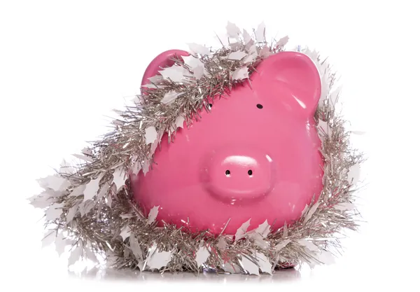 Piggy bank wrapped in Christmas tinsel — Stock Photo, Image