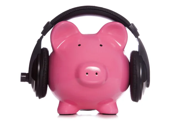 Piggy bank hoofdtelefoon dragen — Stockfoto