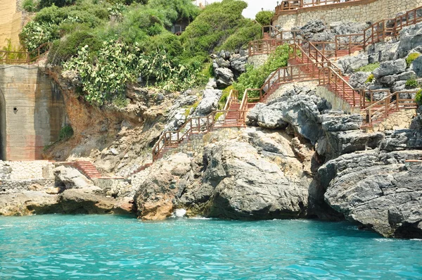 A costa do mar rochosa com uma escada no mar — Fotografia de Stock