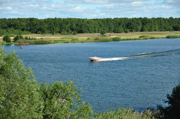Nehrin aşağısında motorlu tekne yüzer — Stok fotoğraf