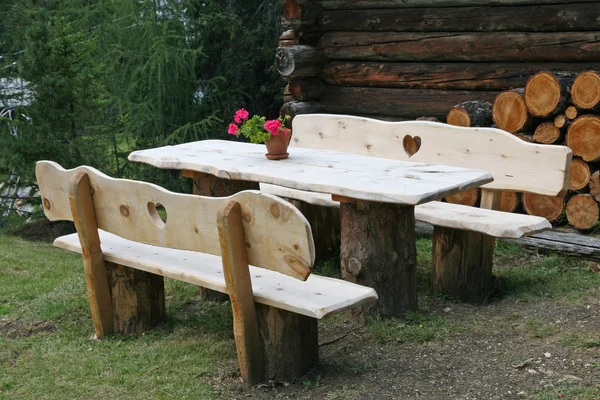 Houten bench met gegraveerde hart en bloem vaas — Stockfoto