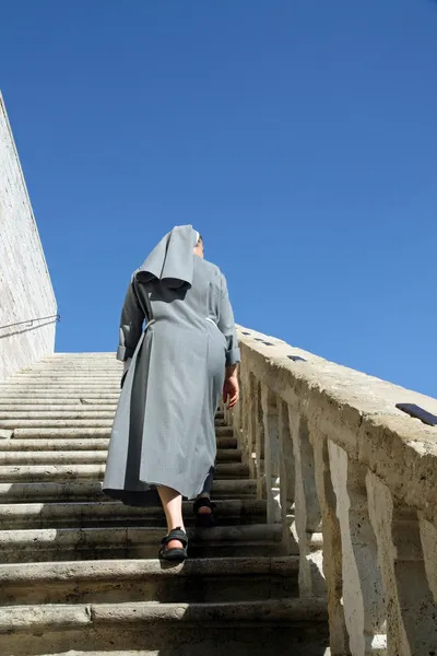 Un with grey dress that goes up the stairs — Stock Photo, Image