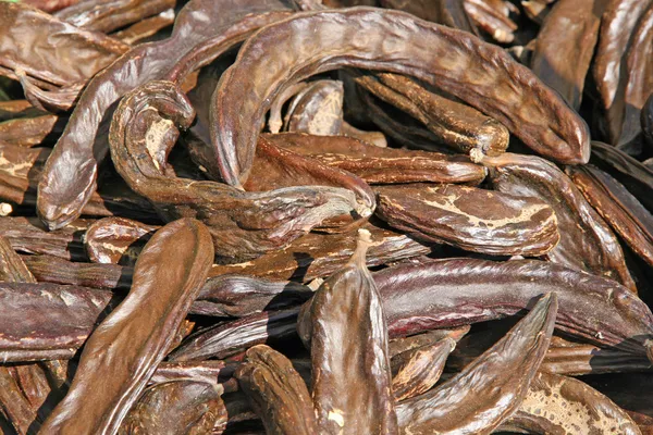 Vele johannesbroodbomen gedroogde bruine voor verkoop aan de markt — Stockfoto