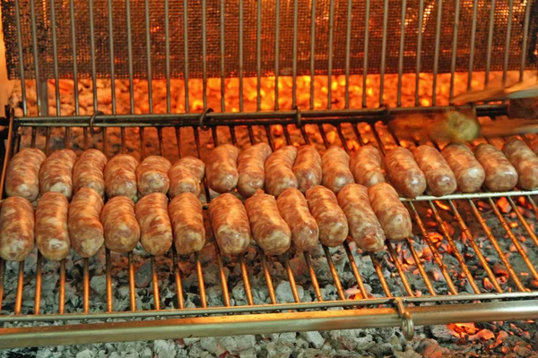 Salsichas grelhadas cozidas na lareira com fogo de lenha — Fotografia de Stock
