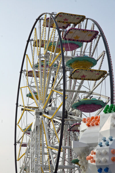 Big wheel with baskets and carriages in an amusement park