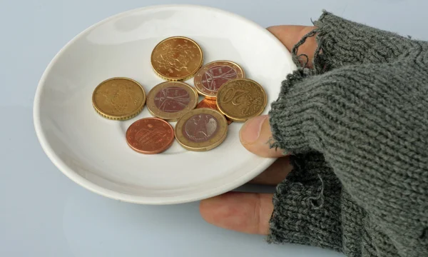 Platillo con monedas en el interior sostenido por un hombre pobre — Foto de Stock