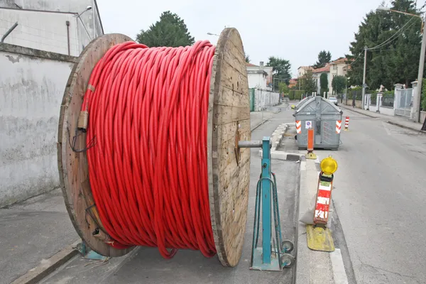 Spool of cable and fiber optics in the road during the outdoor a — Stock Photo, Image