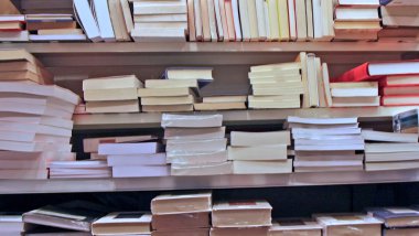 bir de Kütüphane içinde birbiri üstüne yığılmış kitaplar