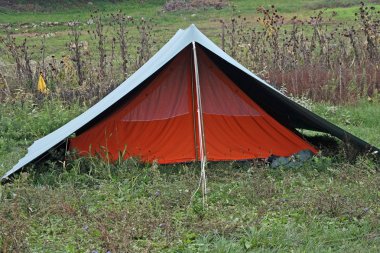 çadır yeşil çatılı hillside çayır üzerinde monte edilmiş.