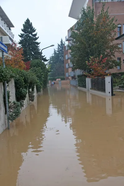 Route inondée lors d'une averse de pluie dans la ville avec immeuble — Photo