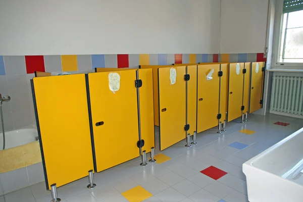 Small bathrooms with yellow doors of kindergarten — Stock Photo, Image