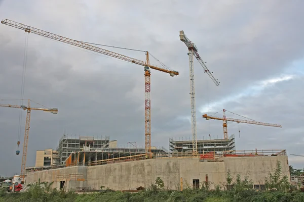 Guindaste em um canteiro de obras de um edifício de concreto sob constr — Fotografia de Stock