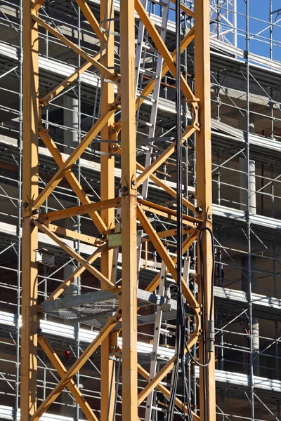 Guindastes e andaimes em um canteiro de obras — Fotografia de Stock