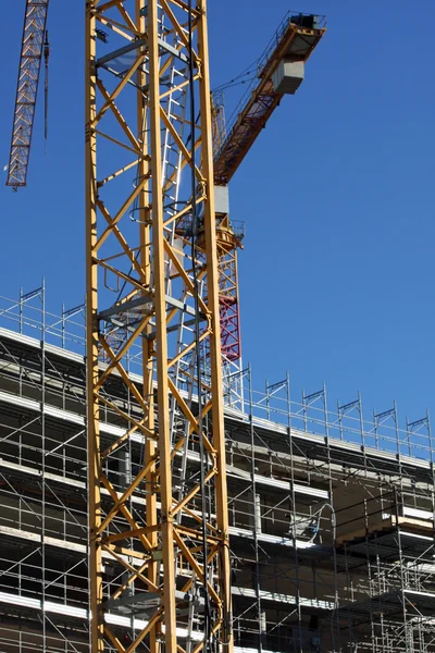 Grúas y andamios en una obra de construcción — Foto de Stock