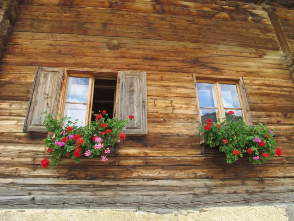 Balcones floreados en una antigua casa de madera —  Fotos de Stock