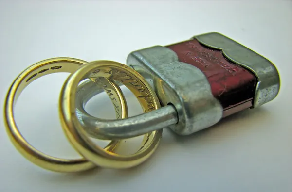 Padlock met twee ringen van het huwelijk aan elkaar gekoppeld voor eeuwig — Stockfoto