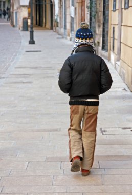 Yalnız çocuk ceket ve yün kap ile yürüyüş ıssız ro